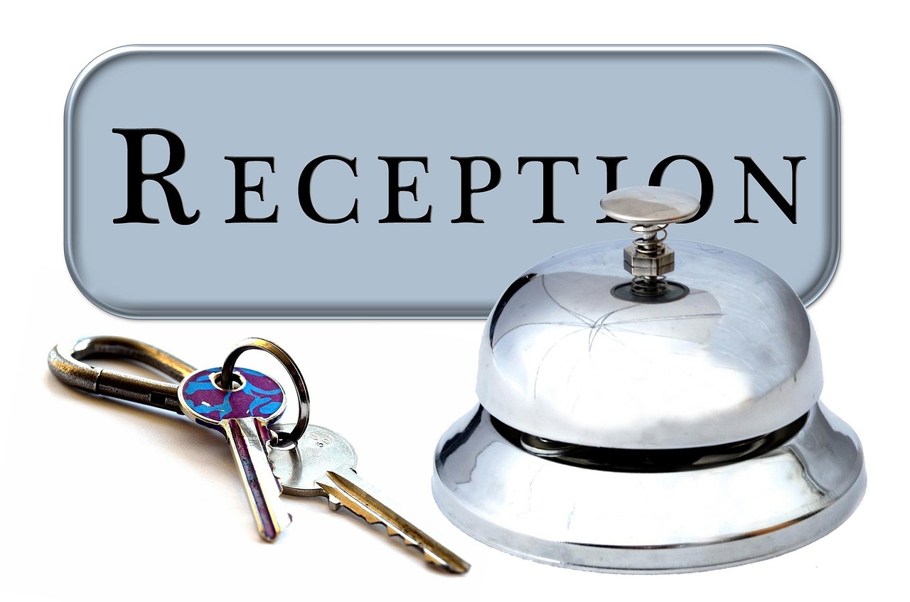 A luxury hotel lobby reception desk with a service bell and blurred background.