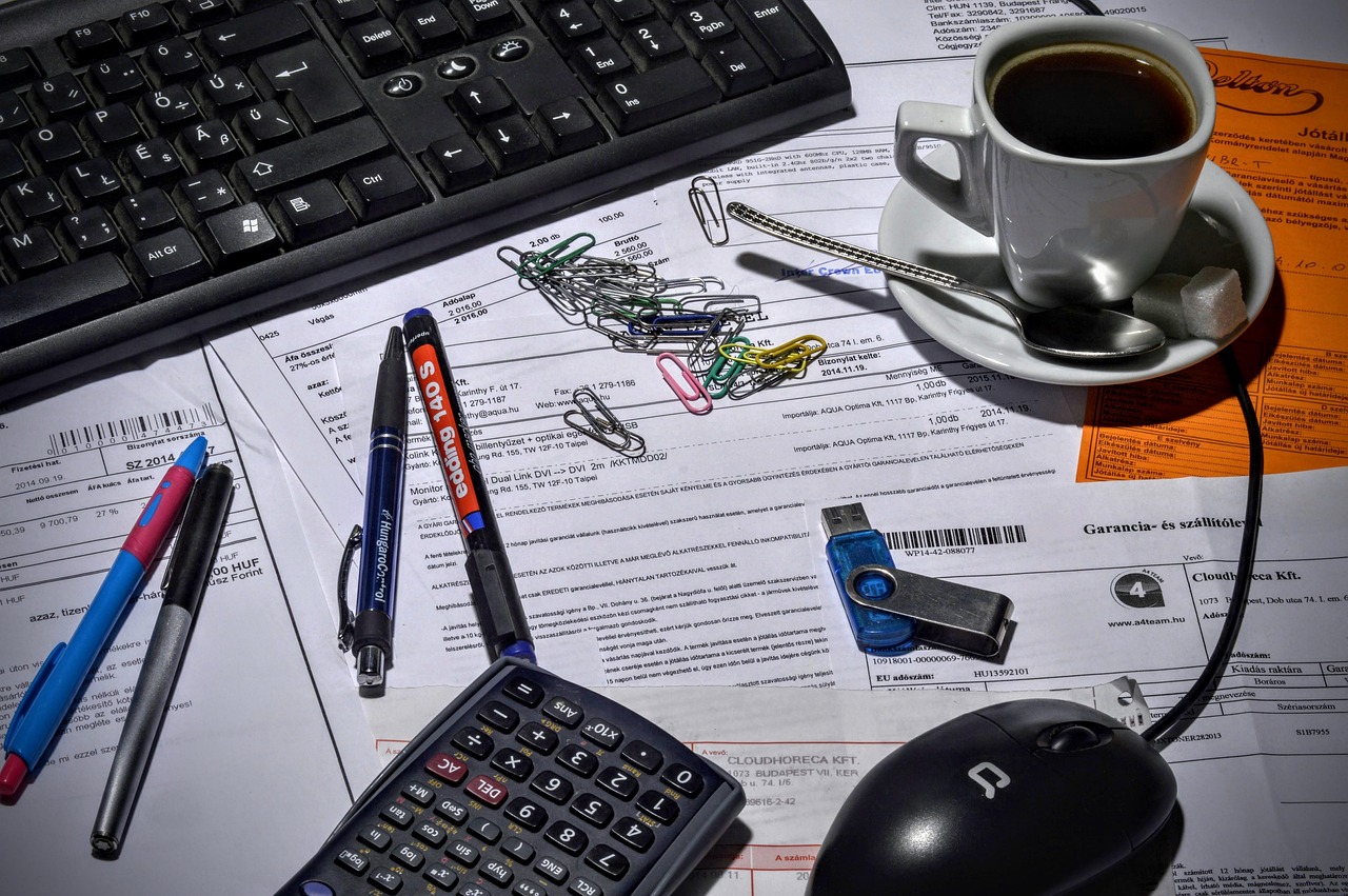 Neatly arranged financial documents, a calculator, and a pen on a desk.