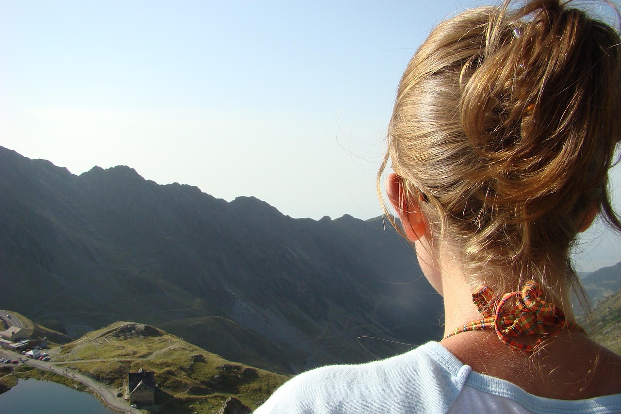 A silhouette of a person climbing a mountain at sunrise representing overcoming obstacles.