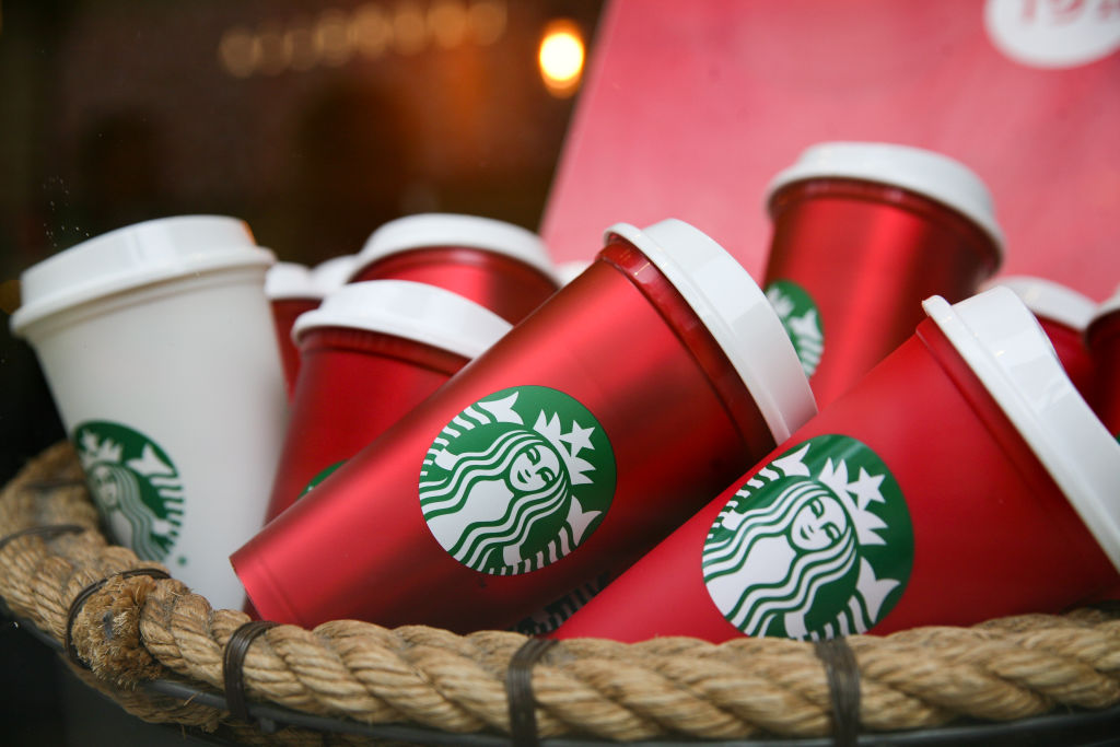 Close-up of the Starbucks coffee shop logo centered on a reusable holiday red cup.