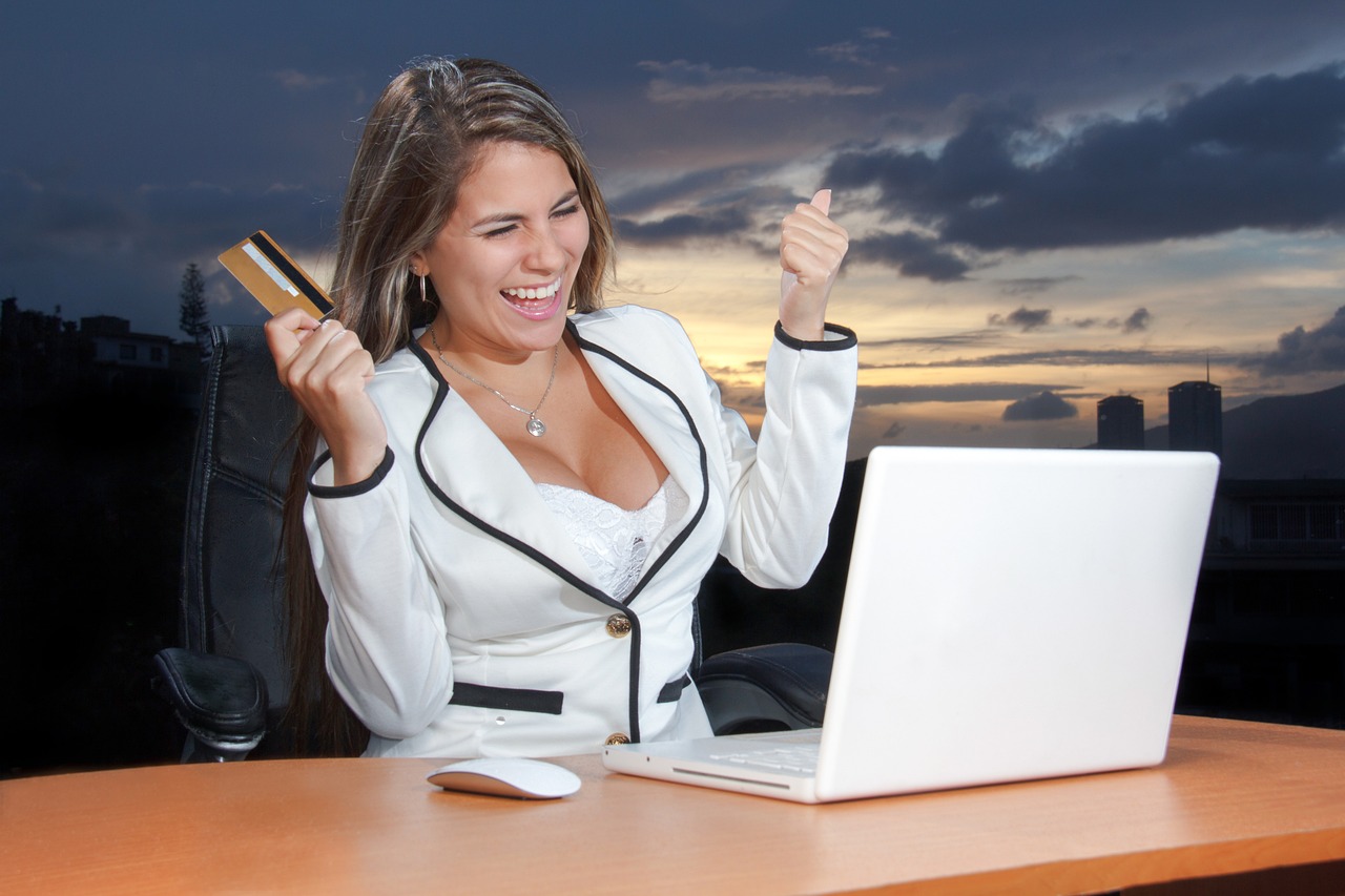 A person using a laptop with a credit card nearby, symbolizing digital transactions.