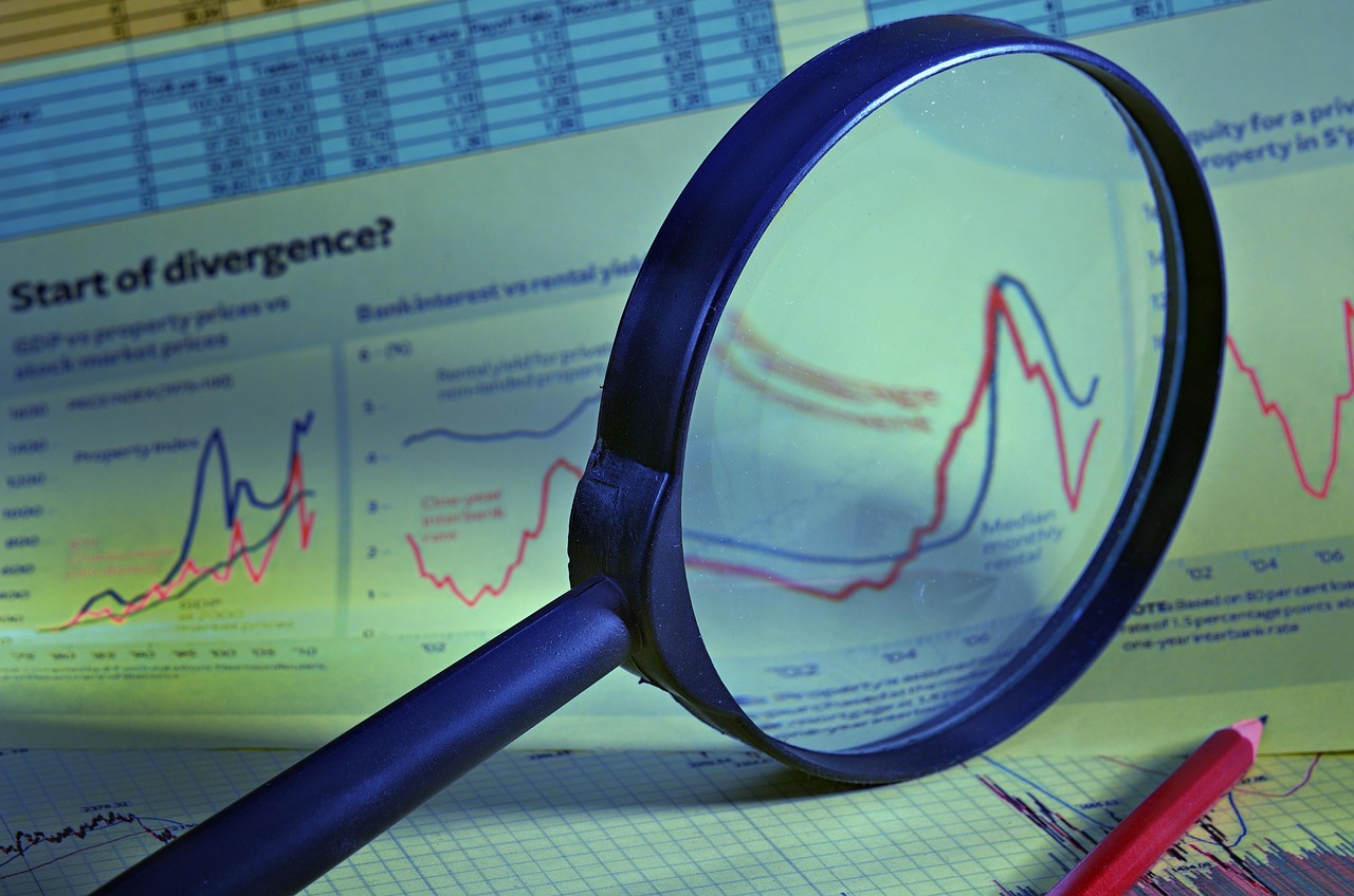 A magnifying glass inspecting financial documents and IRS forms