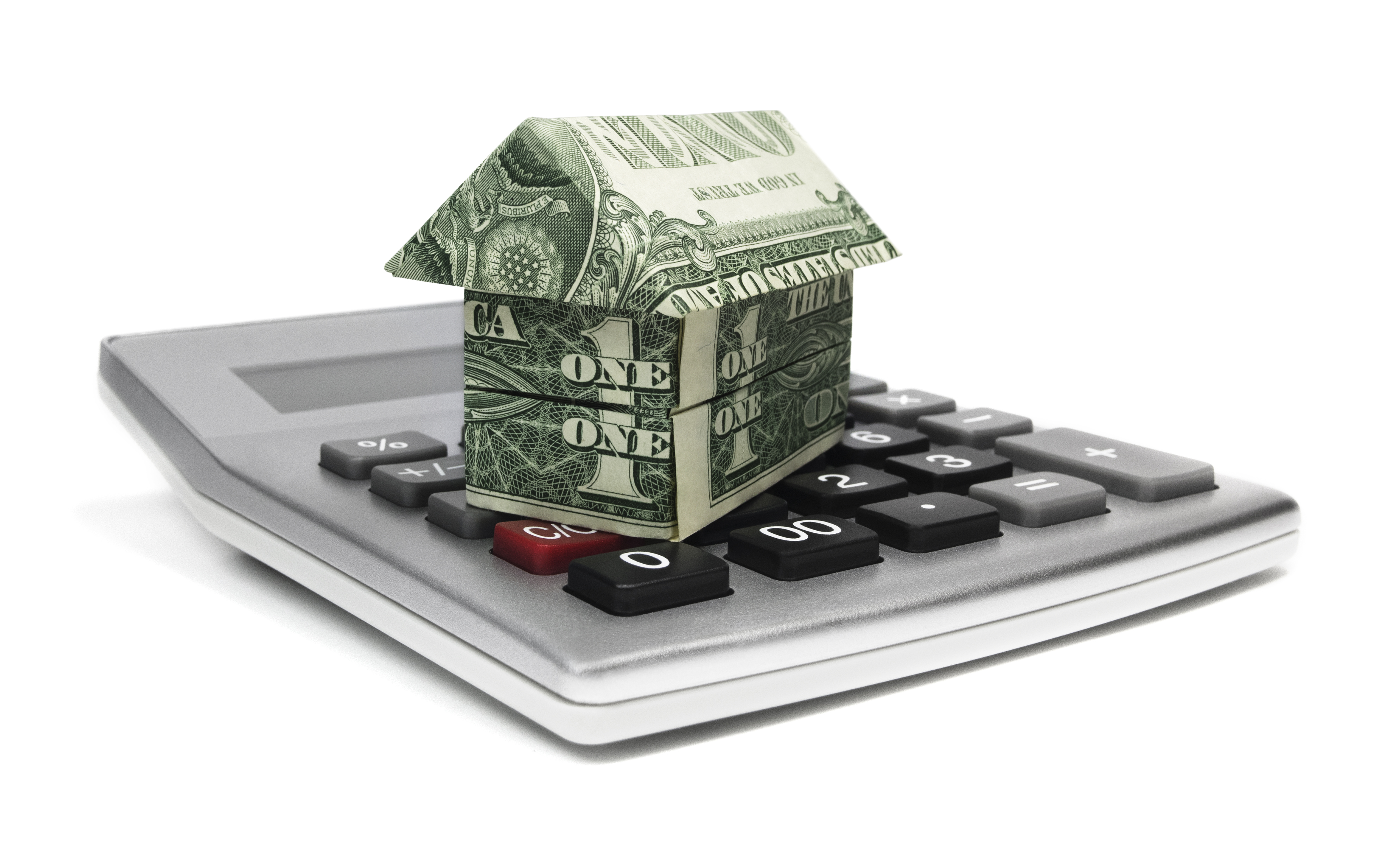 A calculator sitting next to a small origami house representing home equity calculation.
