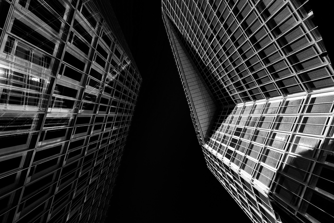 A modern glass banking headquarters reflecting the sky, symbolizing financial stability and growth.
