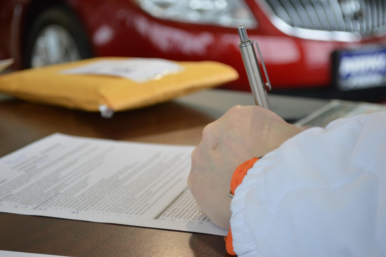 A close-up of a person signing a formal legal agreement or property deed.