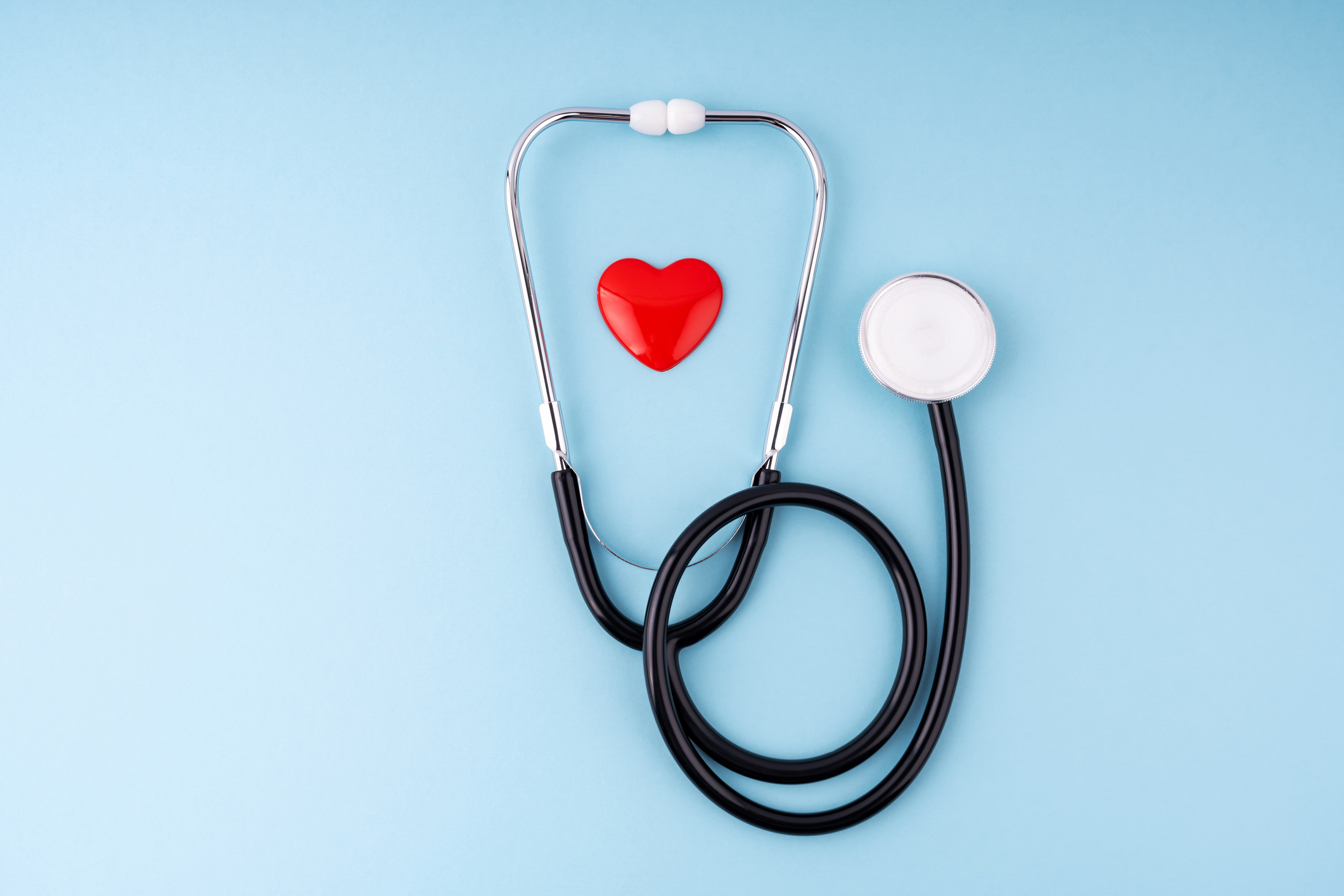 A stethoscope and heart on a blue background representing health care and insurance.
