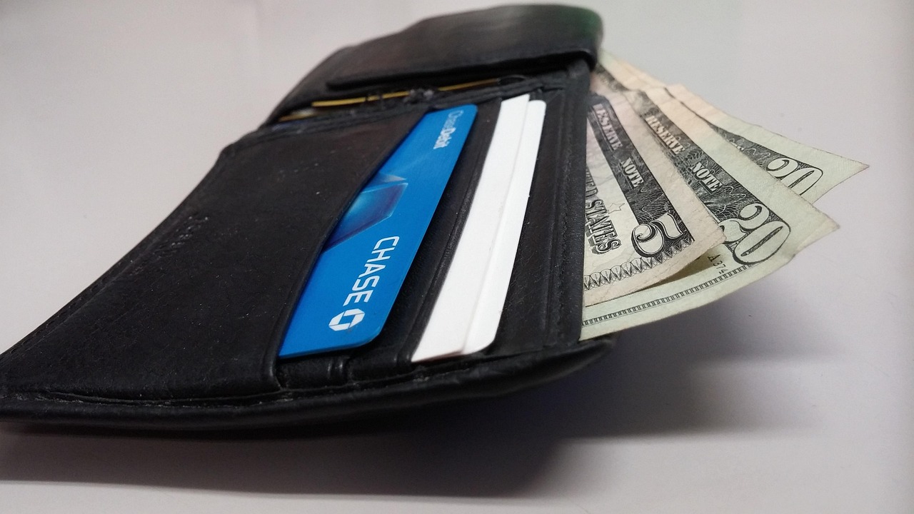 A person holding a credit card over a laptop while making a secure transaction.