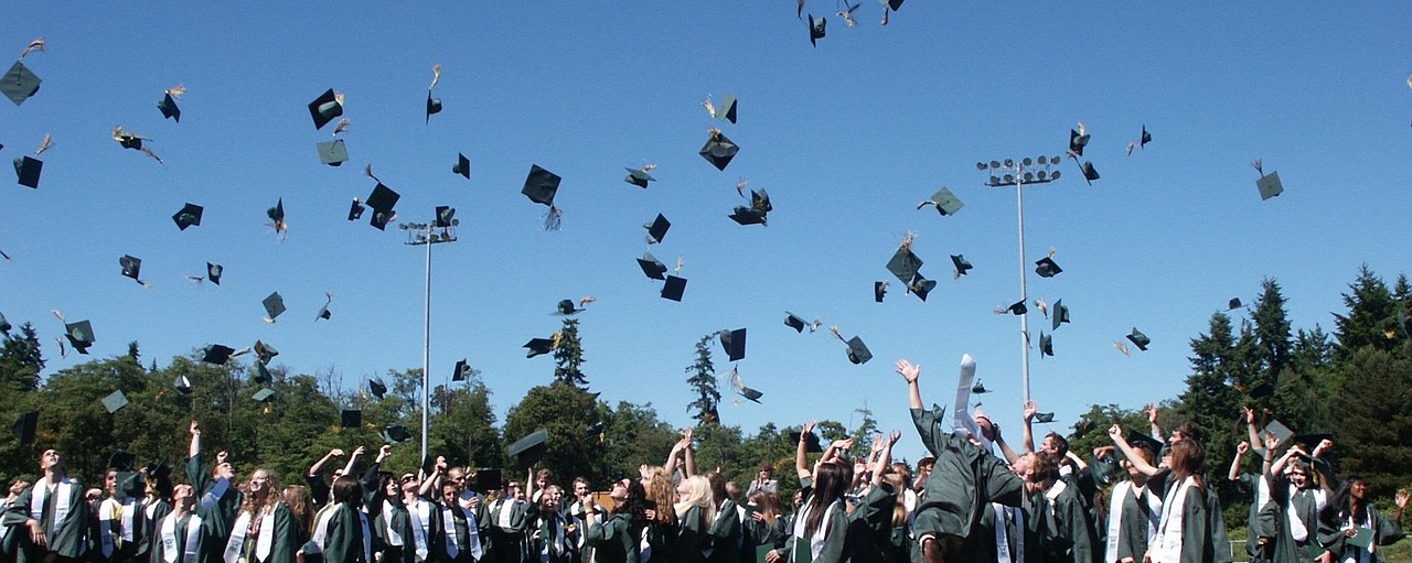 A set of house keys placed next to a graduation cap, representing major life financial commitments.