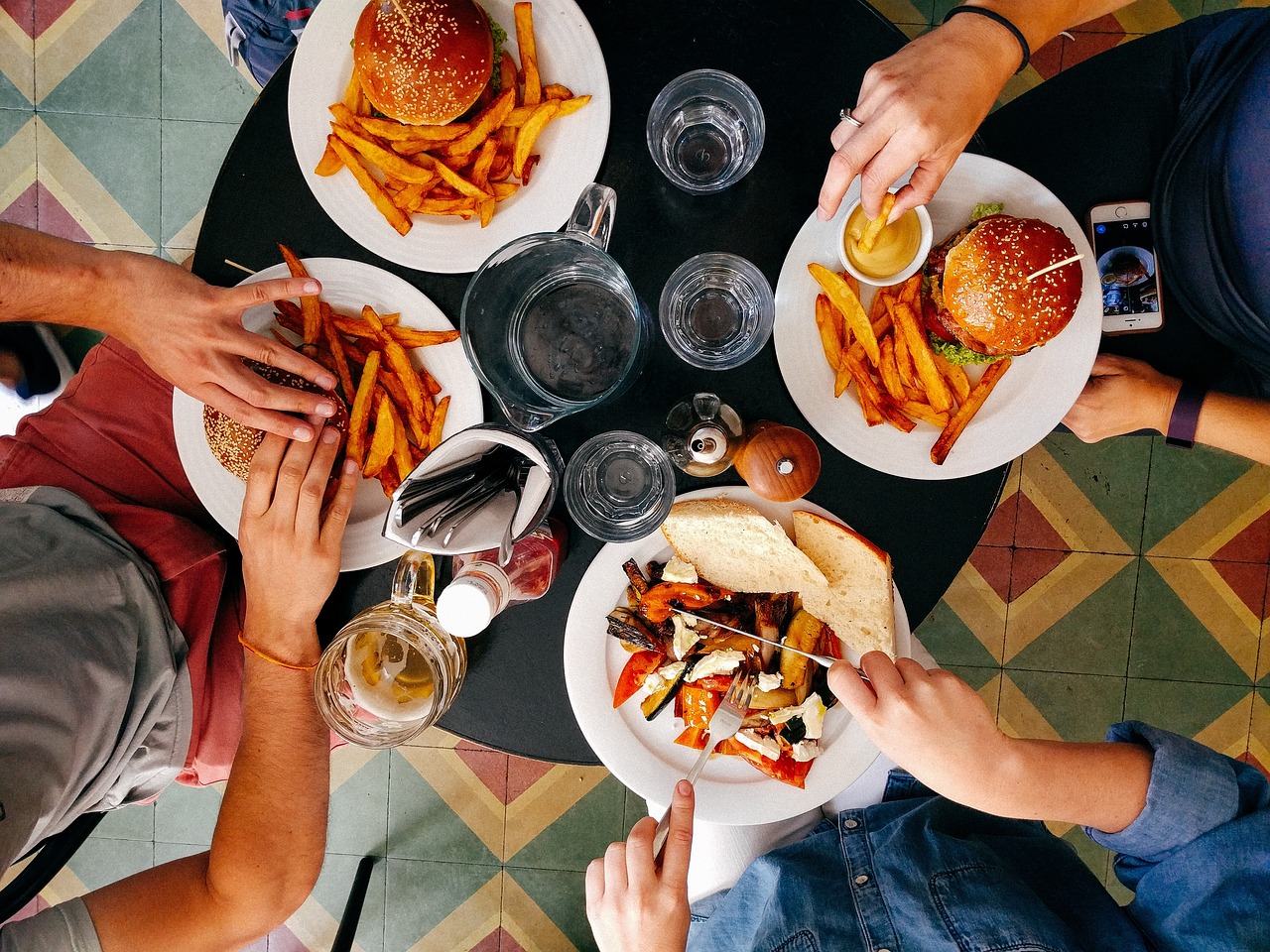 A group of young professionals laughing and sharing a meal at an upscale restaurant.