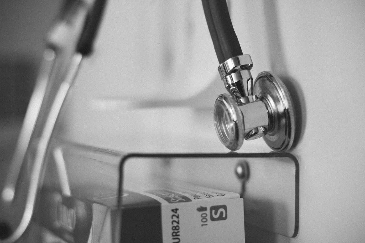 A stethoscope resting next to a white ceramic piggy bank.