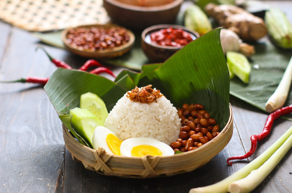 Malaysian breakfast Nasi melak served on a pandan leaf with coconut rice and curry.