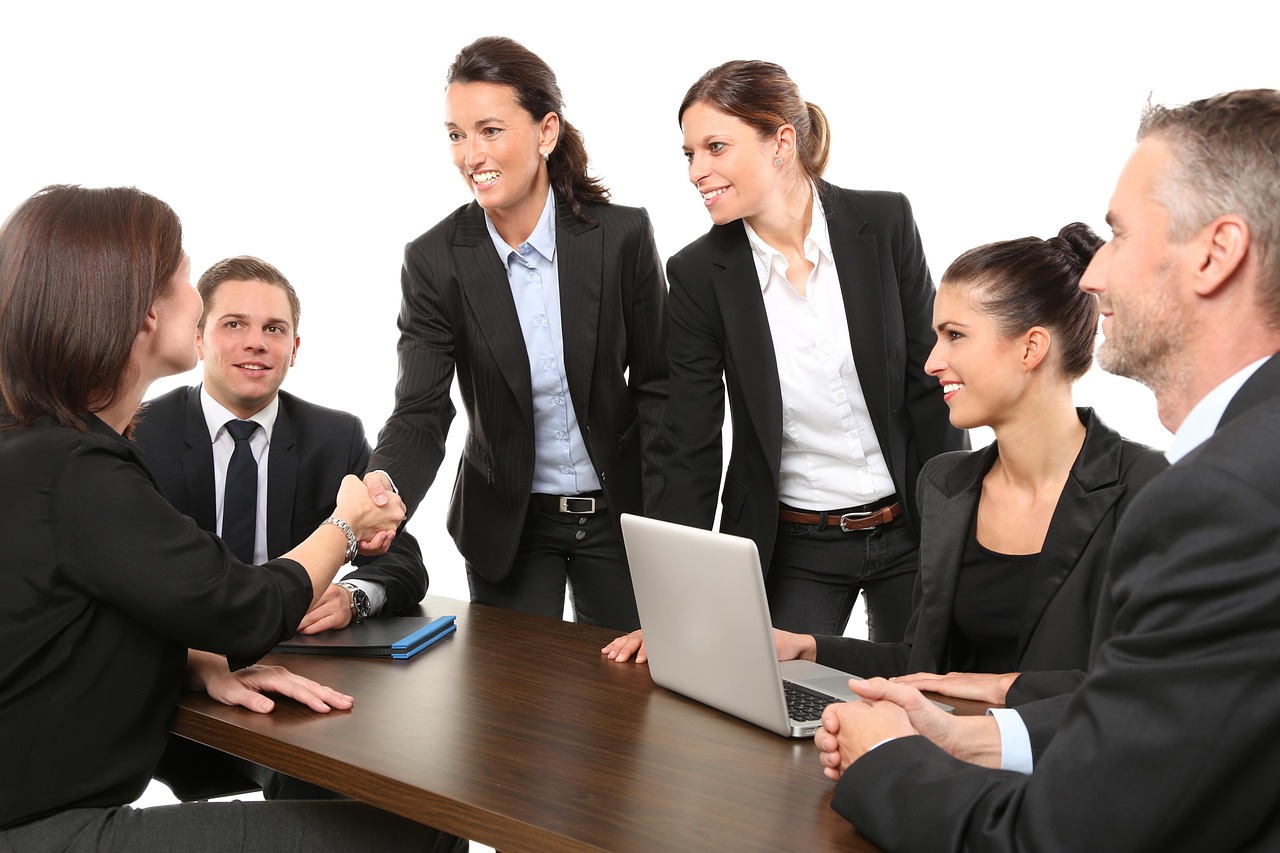 A professional handshake in a bright, modern corporate office