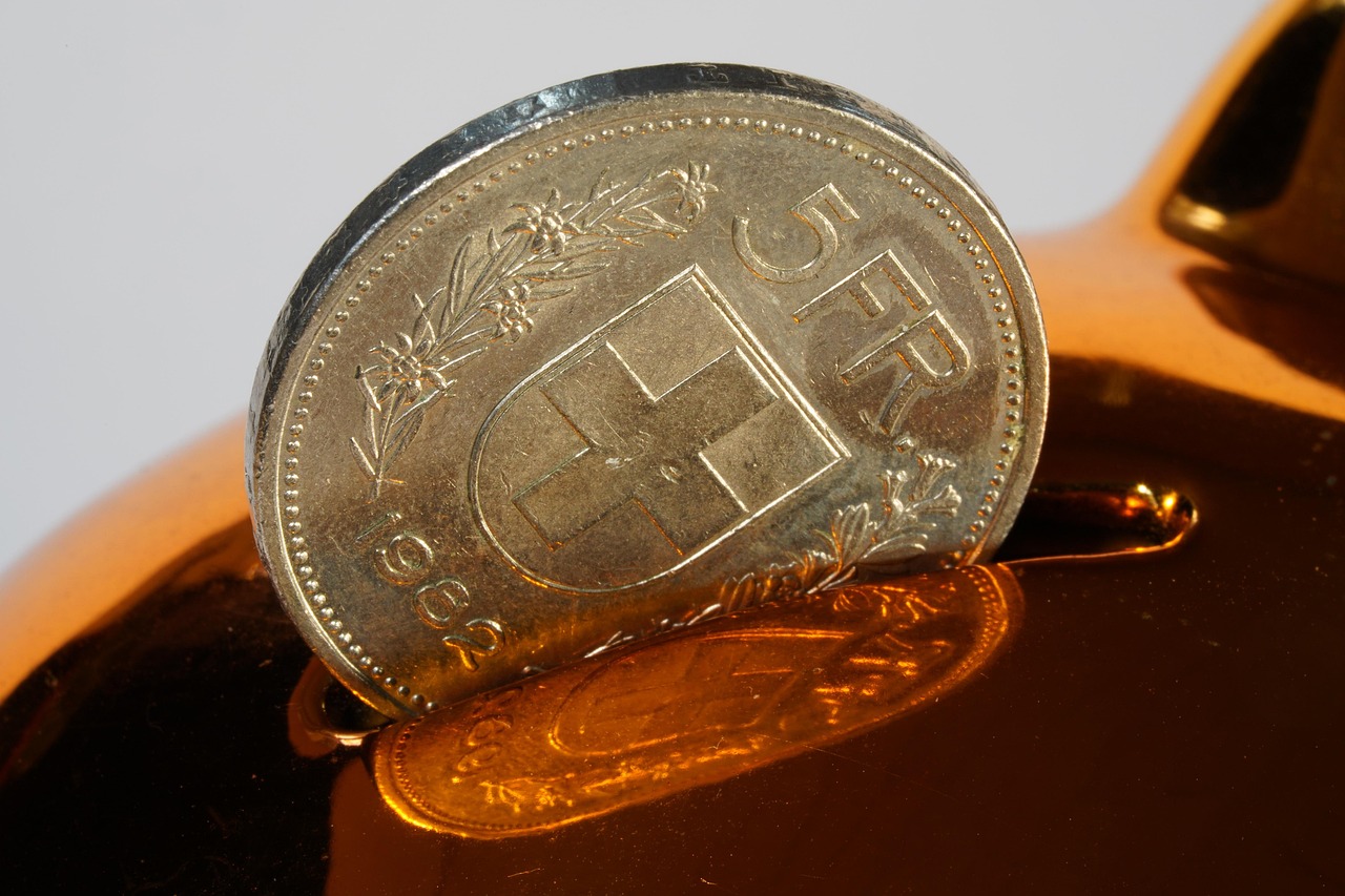 A transparent glass jar filled with coins and a small plant growing out of it, symbolizing savings growth.
