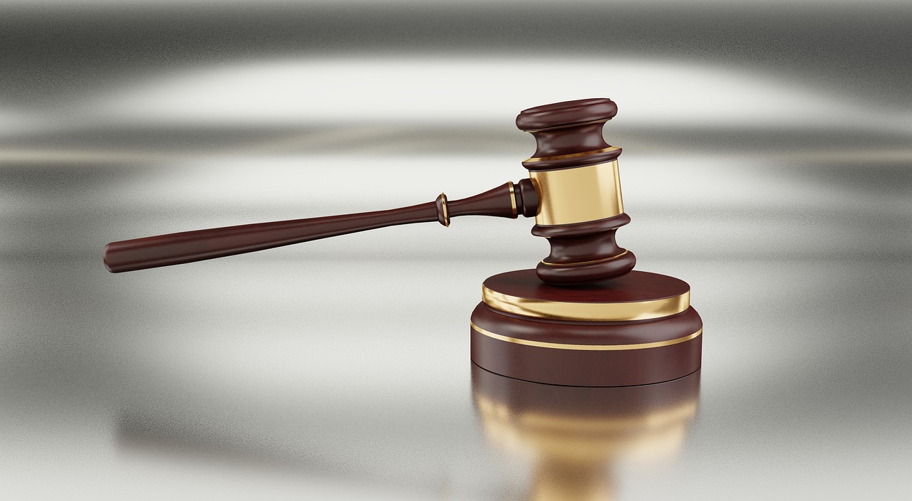A wooden gavel resting on a desk with legal documents symbolizing litigation protection.