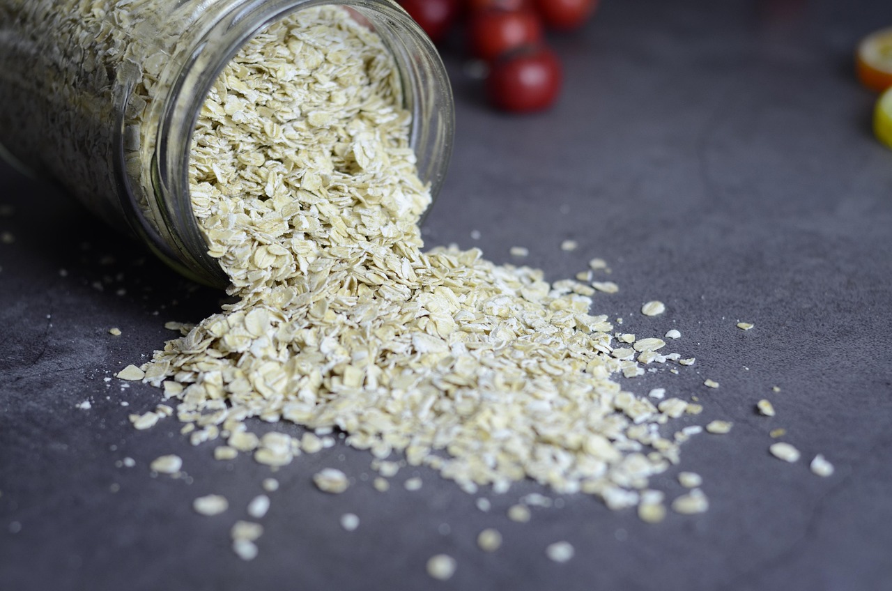 Glass jars filled with dry lentils, oats, and grains on a kitchen counter.