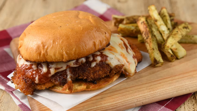 A completed Home Chef chicken parmesan sandwich with a side of fries on a plate.