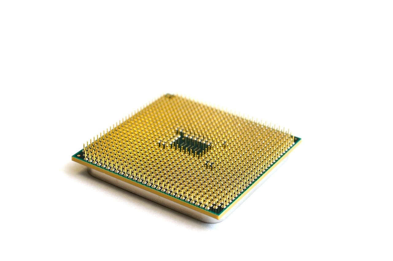 Macro view of a gold-plated semiconductor chip representing the hardware infrastructure of AI.