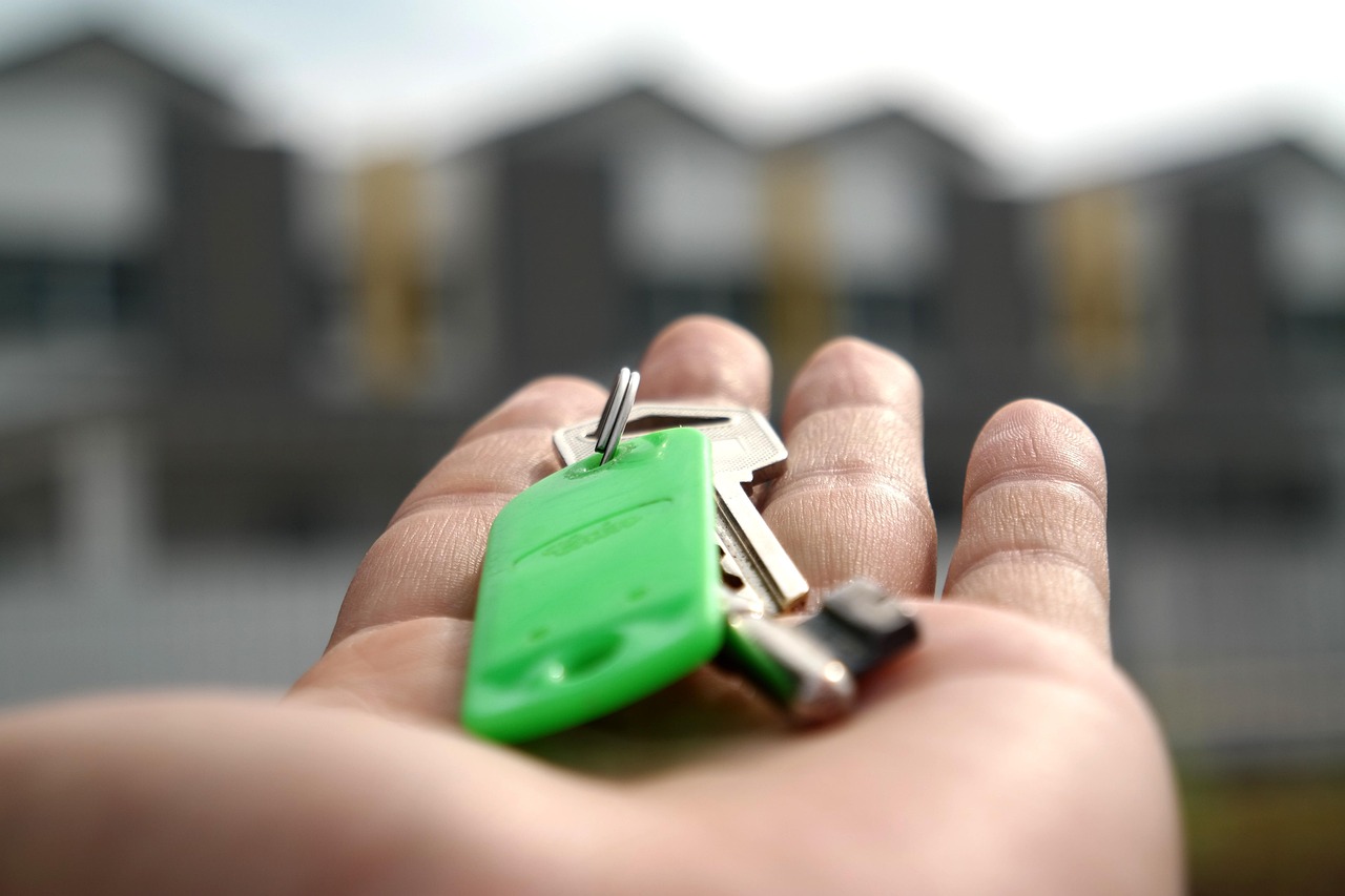 A person holding the keys to a new home, representing successful asset use.