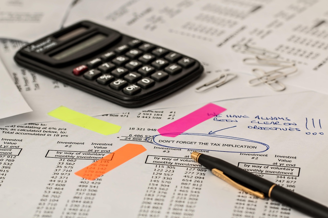 A calculator sitting on top of tax forms and financial charts.