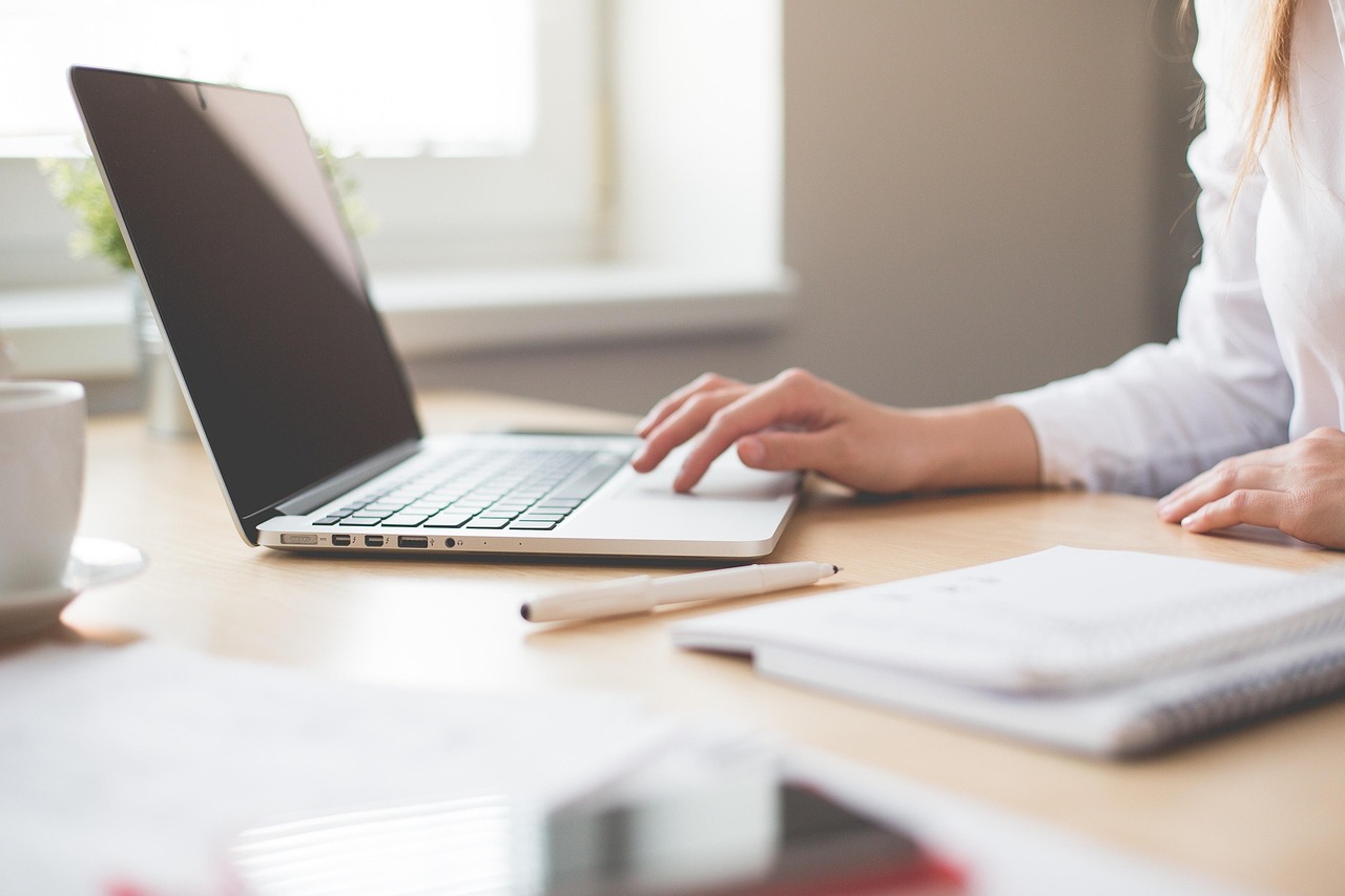 A clean office workspace with a laptop open to a banking site.