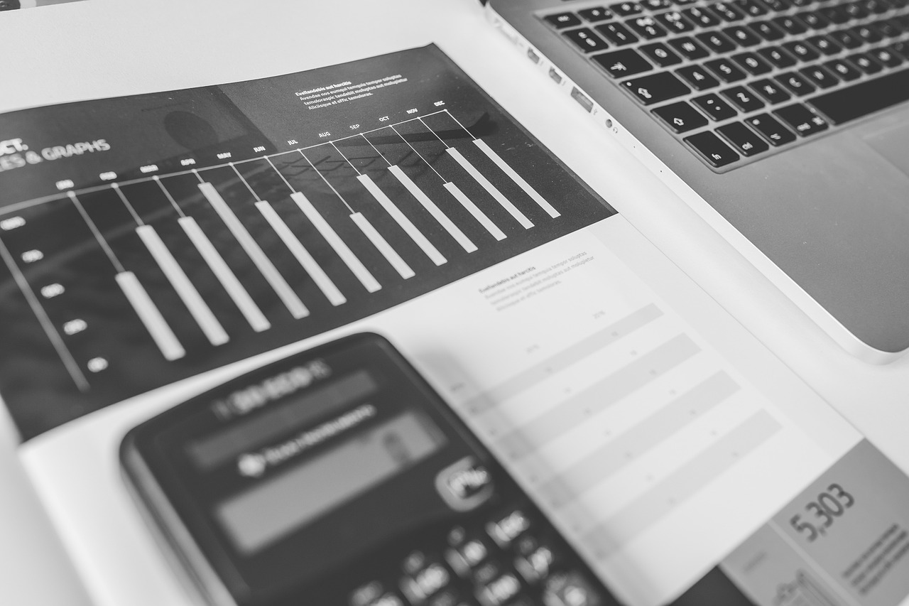 An overhead view of a calculator and financial documents on a desk.