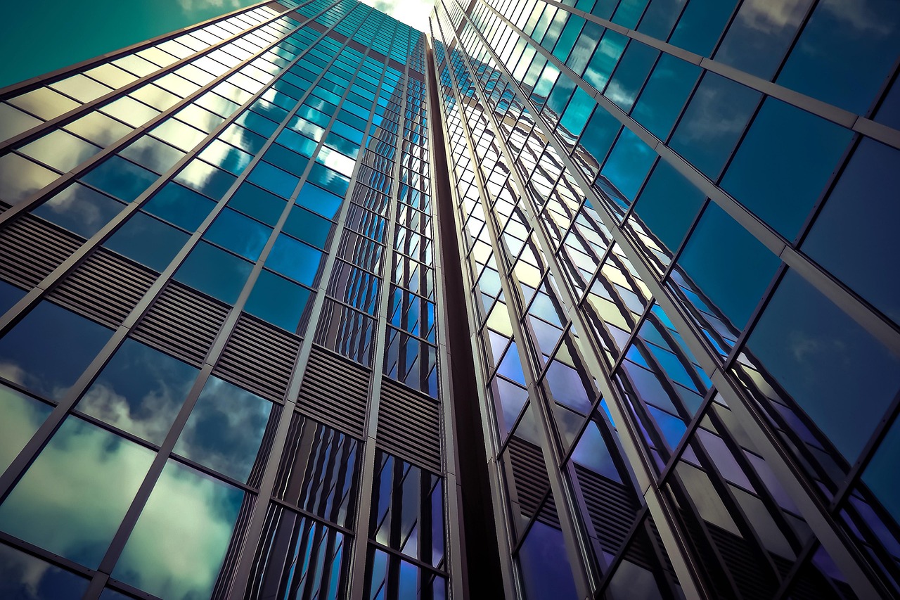 A tall glass-clad modern bank building reflecting the sky, representing strength and security.