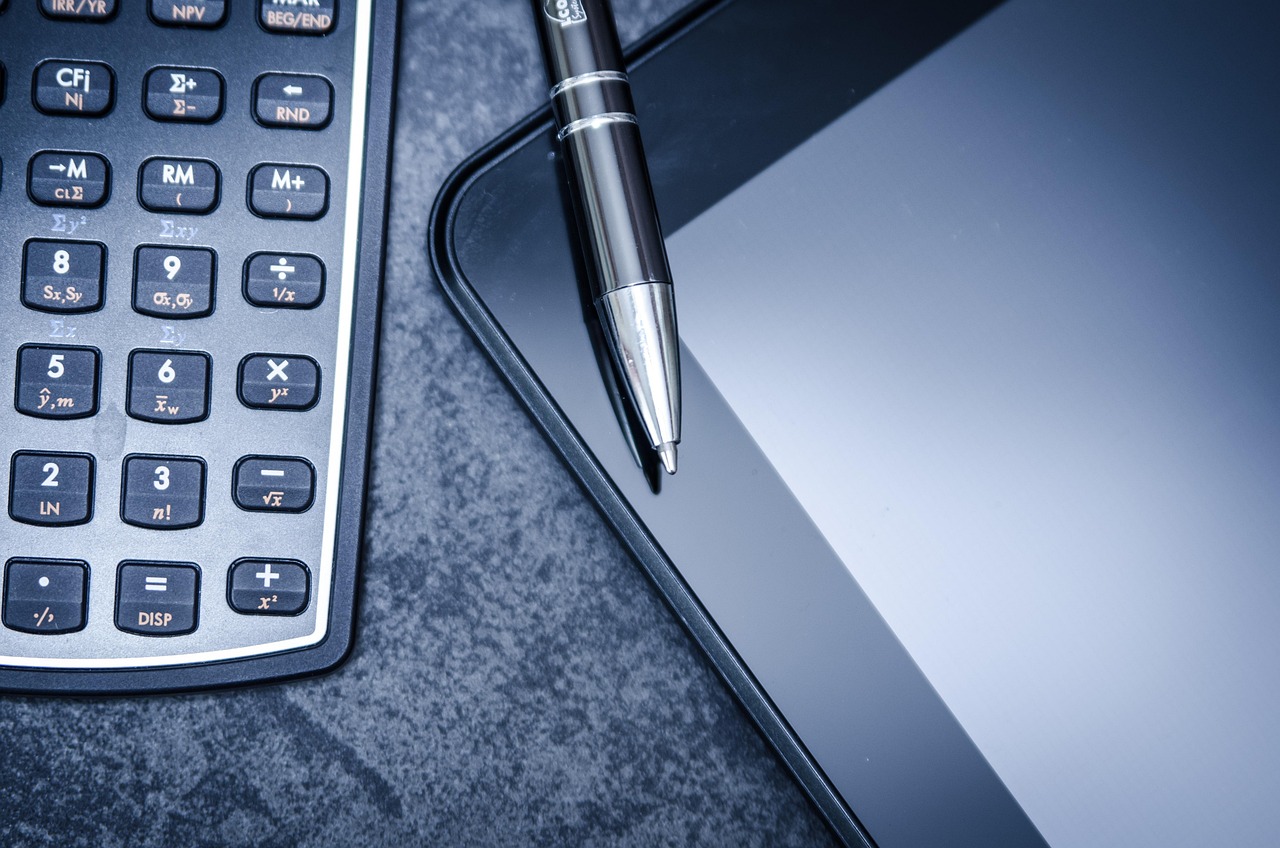Close up of an organized desk with a calculator and tax documents, symbolizing audit readiness.