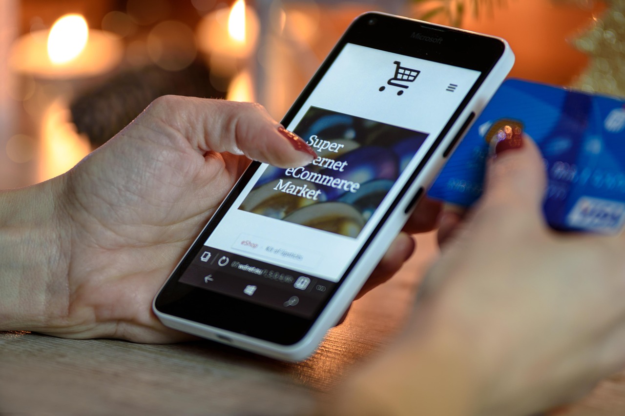 A person using a smartphone next to a credit card to manage business transactions.