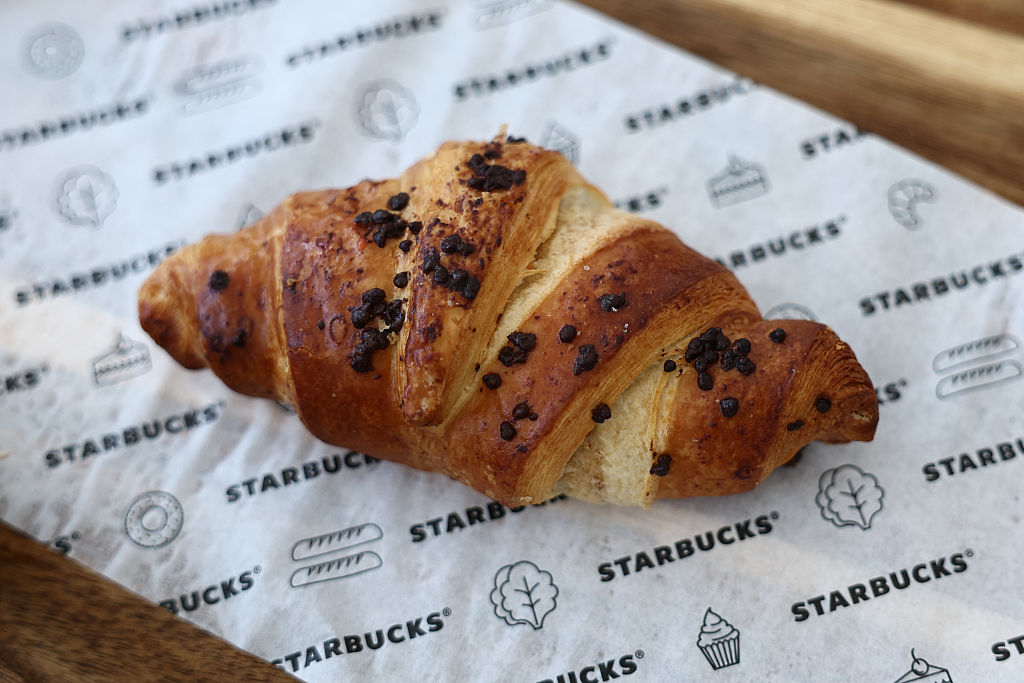A Starbucks chocolate and nut croissant served on a festive table.