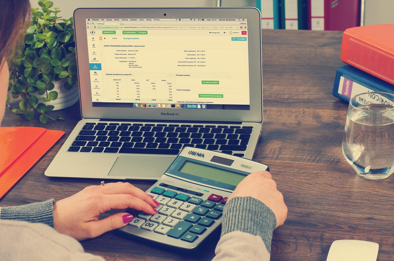 A professional desk setup with a calculator, personal finance documents, and a credit card.