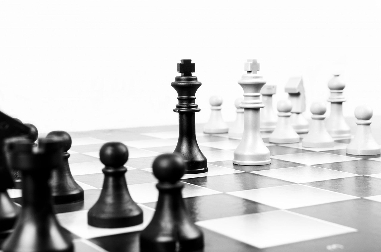 A strategic chess move being made on a clean glass board.