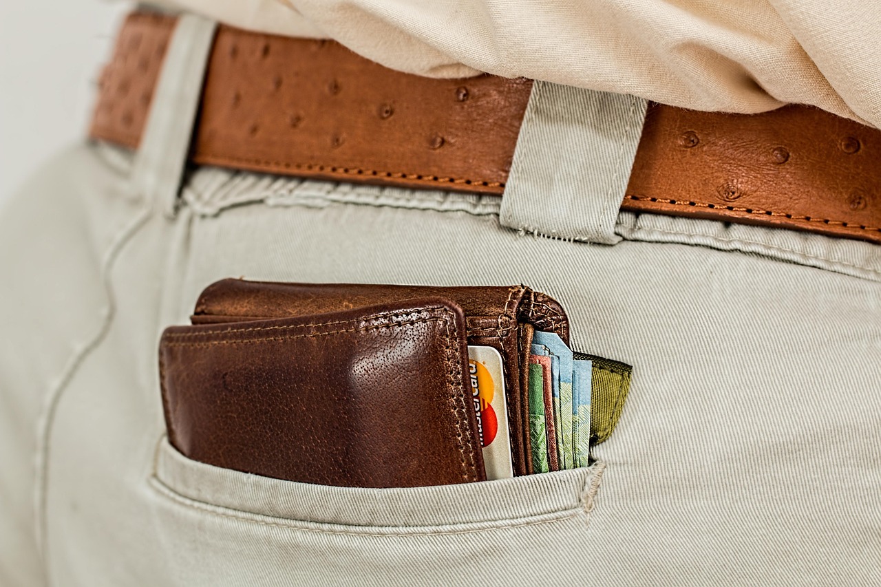 A person holding an organized leather wallet with only necessary cards inside.