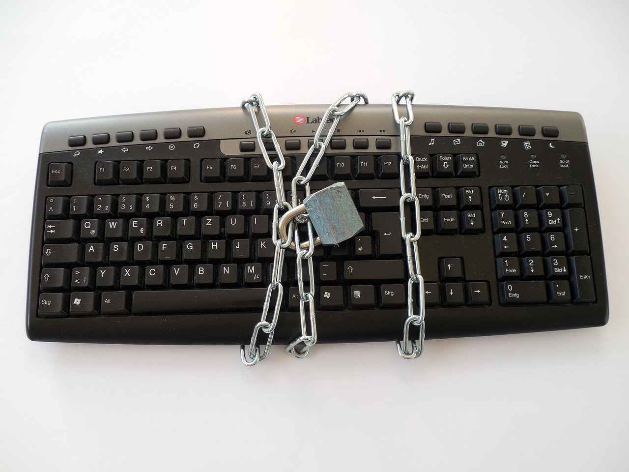 A physical padlock resting on a laptop keyboard symbolizing restricted access or security protocols.